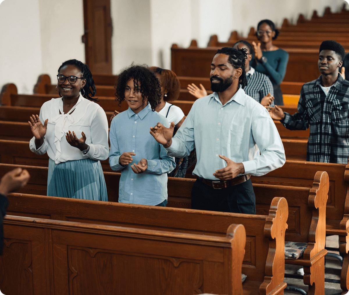 People standing and clapping in a church.